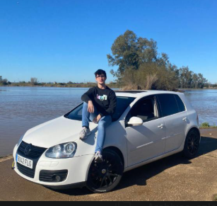 Casto junto a su Golf blanco en una parada junto al agua